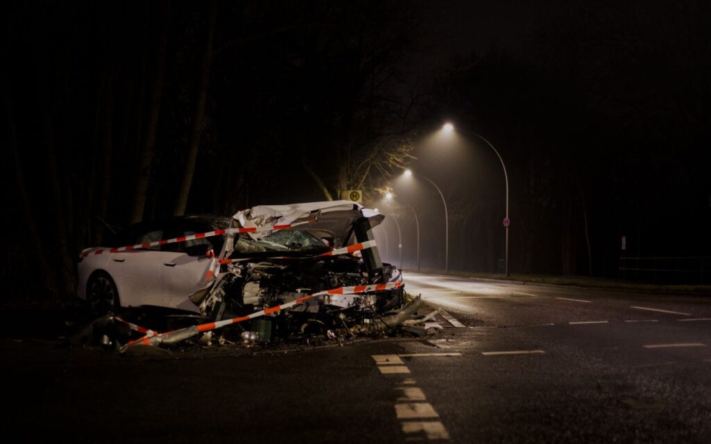 A Wrecked Car After A Crash On A Dimly Lit Street In Berlin At Night.
